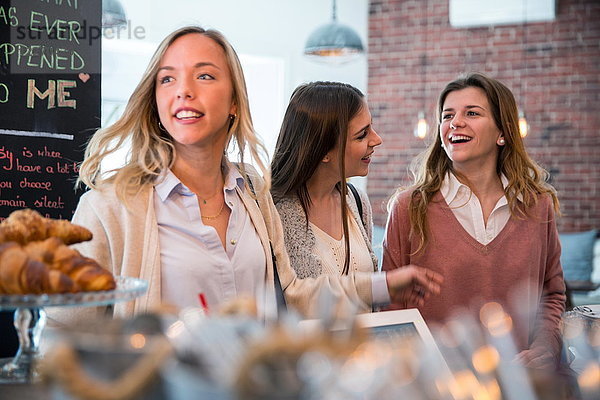 Drei Freundinnen im Café  die darauf warten  bedient zu werden