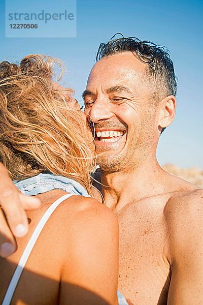 Reifere Paare im Freien  tragen Badesachen  umarmen sich  lachen