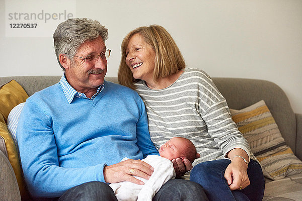 Großeltern auf Sofa mit Baby-Enkelin