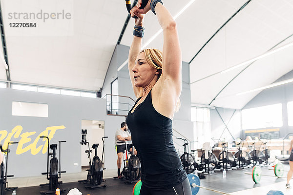 Gewichtheben einer Frau mit Kesselglocke im Fitnessstudio
