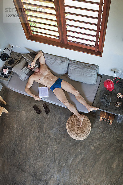 Reifer Mann in Unterhosen schläft auf Sofa  Draufsicht