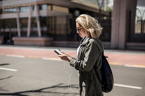 Frau benutzt Mobiltelefon auf der Straße  Kapstadt  Südafrika
