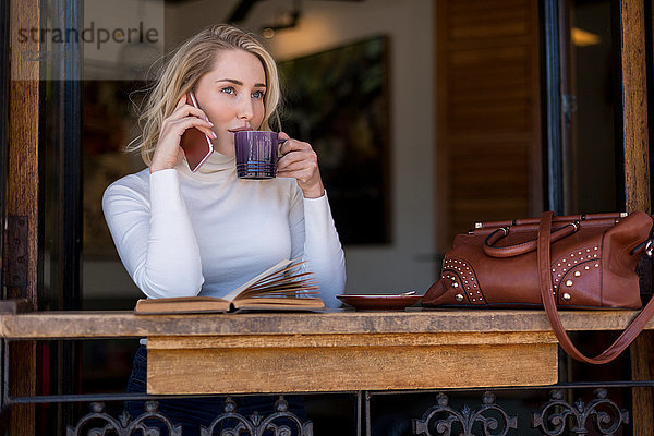 Frau am Mobiltelefon im Café  Kapstadt  Südafrika