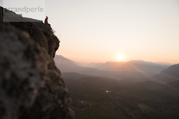 Frau auf der Hügelspitze bei Sonnenaufgang  Rattlesnake Ledge  Washington  USA