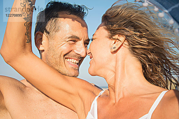 Erwachsenes Paar am Strand  von Angesicht zu Angesicht  lächelnd