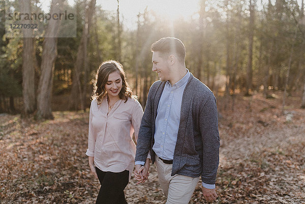 Junges Paar hält sich an den Händen und geht im Wald spazieren  Ottawa  Kanada