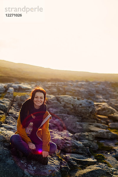 Frau sitzt auf Felsen  Fanore  Clare  Irland