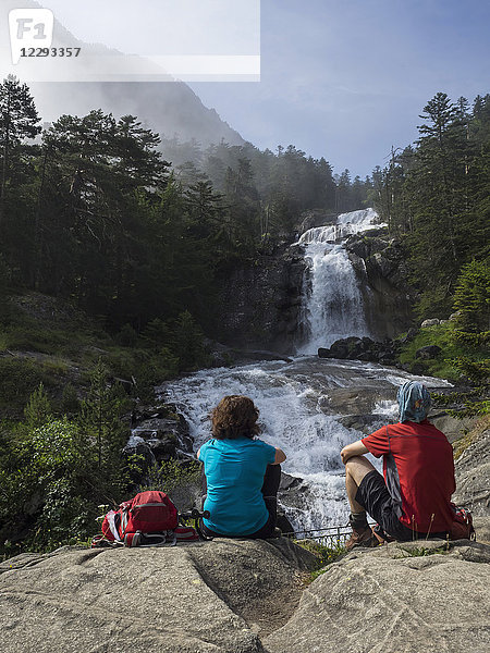 Wanderer bewundern die malerische Aussicht auf einen Wasserfall im Fluss Gave De Gaube  Frankreich