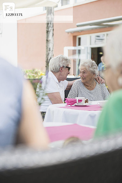 Ältere Frauen sitzen im Freien