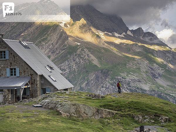 Frau beim Wandern in den Hochpyrenäen  stehend auf einem kleinen Felsen neben dem Refuge des Espuguettes  Gavarnie  Frankreich