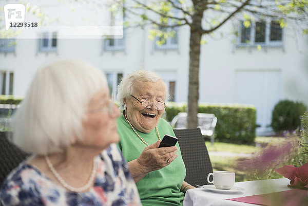 Ältere Frau lachend und mit Smartphone