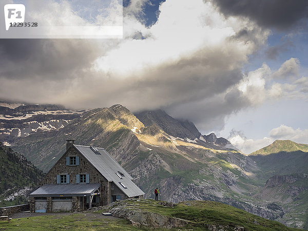 Frau beim Wandern in den Hochpyrenäen  stehend auf einem kleinen Felsen neben dem Refuge des Espuguettes  Gavarnie  Frankreich