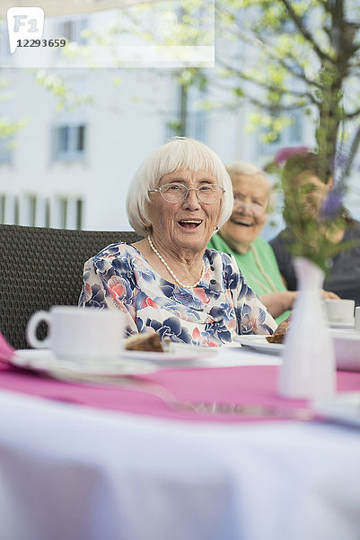 Porträt einer älteren Frau am Frühstückstisch