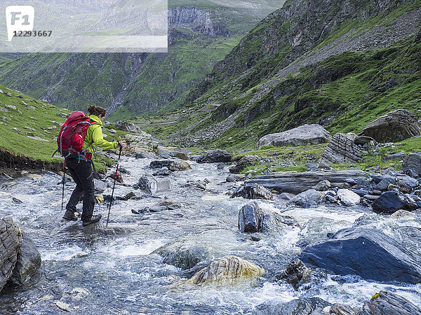 Frau beim Wandern in den Hochpyrenäen in der Nähe des Cirque de Troumouse  Überquerung eines Wildflusses  Frankreich