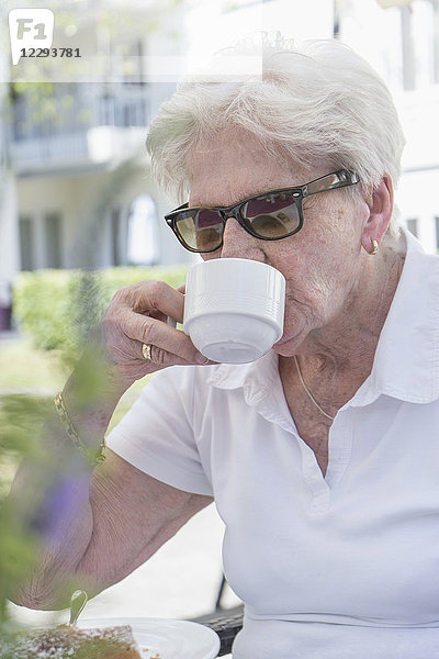 Ältere Frau trinkt Kaffee