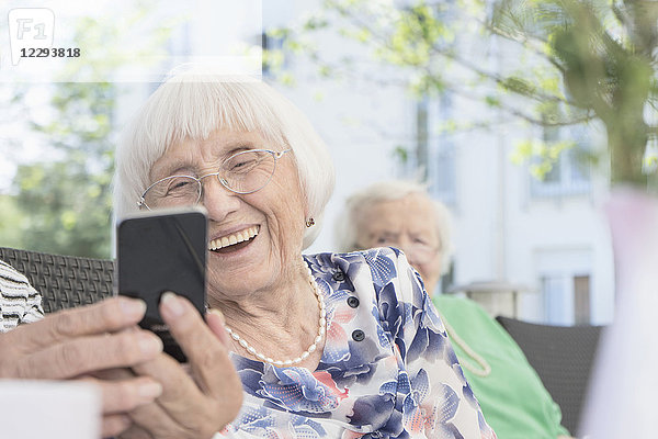 Ältere Frau schaut auf ihr Smartphone