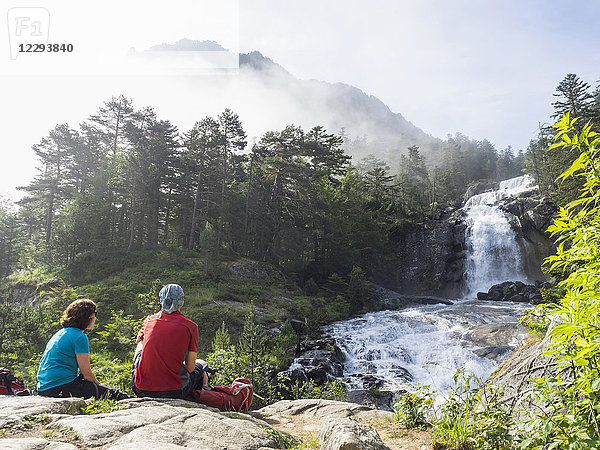 Wanderer bewundern die malerische Aussicht auf einen Wasserfall im Fluss Gave De Gaube  Frankreich