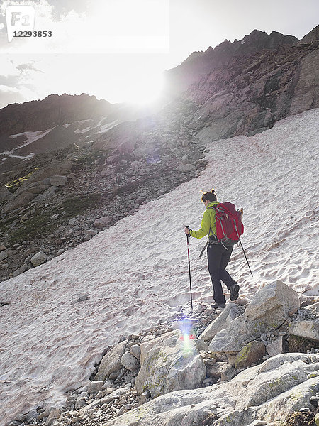 Frau wandert in den Hochpyrenäen und überquert ein Schneefeld beim Aufstieg zum Berg Vignemale  Cauterets  Frankreich
