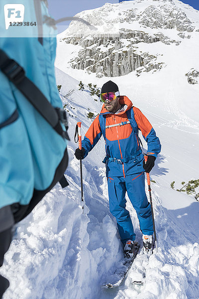 Mann beim Skifahren mit schneebedecktem Berg im Hintergrund