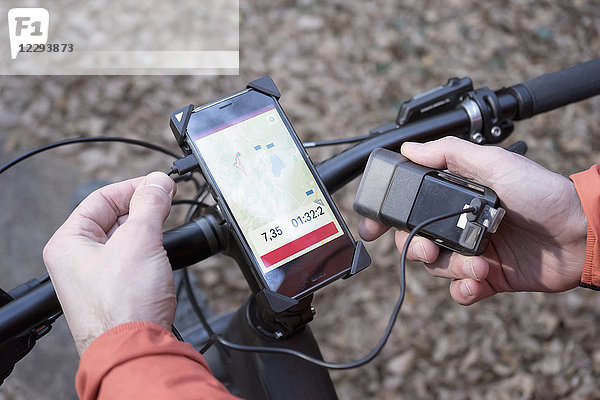 Mountainbiker verbindet GPS-Gerät mit externem Batterieladegerät