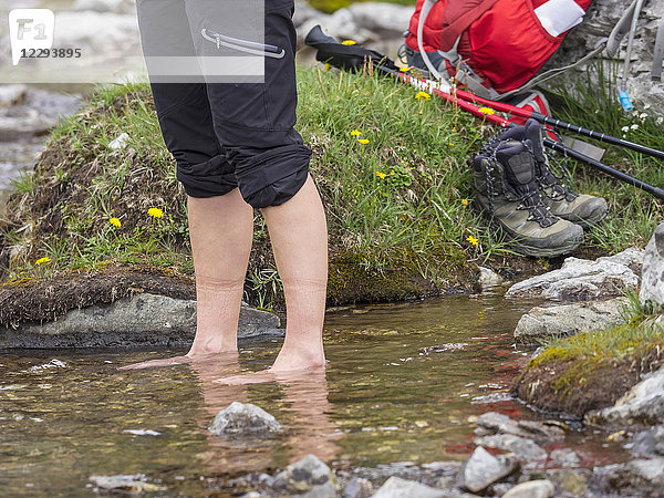 Wanderin steht im Wasser am Flussufer  Gavarnie  Frankreich