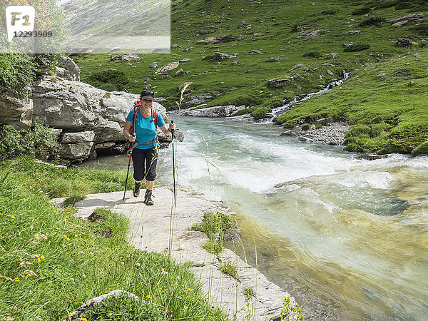 Frau beim Wandern in den Hochpyrenäen am Flussufer der Gaube d'Estaube  Frankreich