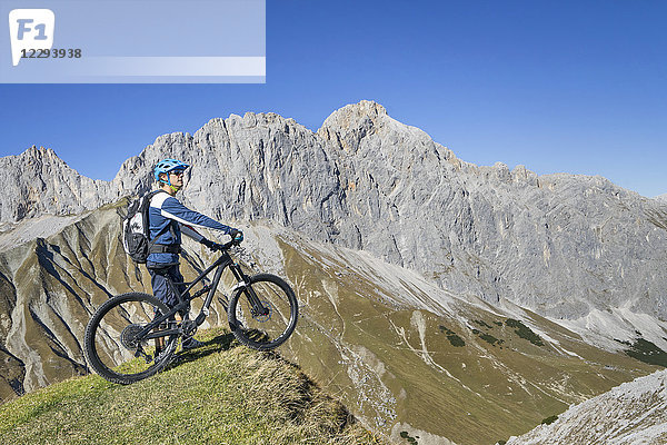 Mountainbiker genießt den Panoramablick auf dem Gipfel eines Berges