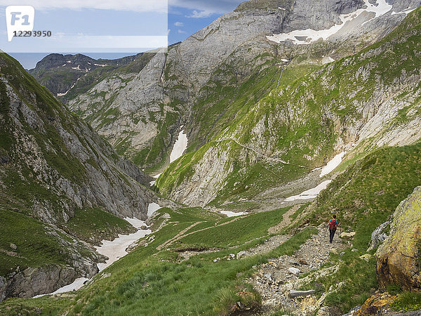 Frau beim Wandern in den Hochpyrenäen beim Abstieg von der Hourquette d'Ossoue zum Tal Barranque d'Ossoue  Gavarnie  Frankreich