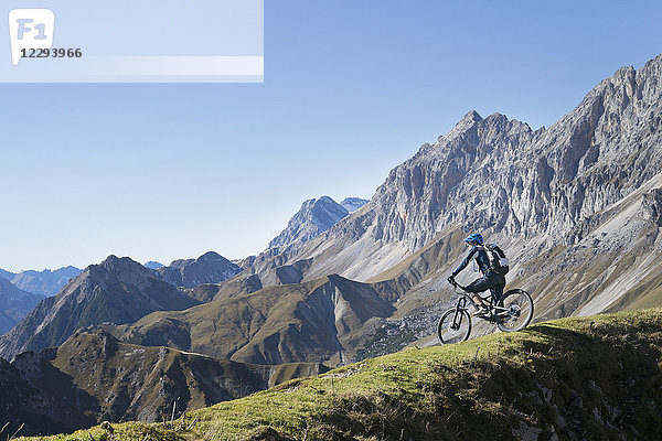 Mountainbiker bewundert die schöne Aussicht auf dem Gipfel eines Berges