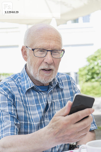 Älterer Mann benutzt ein Smartphone