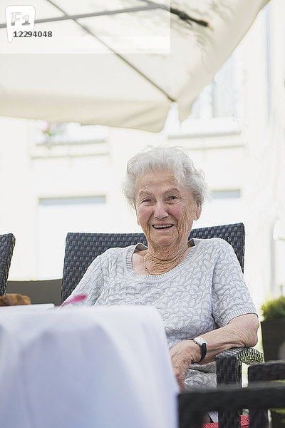 Porträt einer älteren Frau  die auf einem Tisch sitzt
