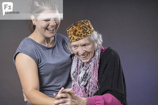 Großmutter und Enkelin tanzen händchenhaltend