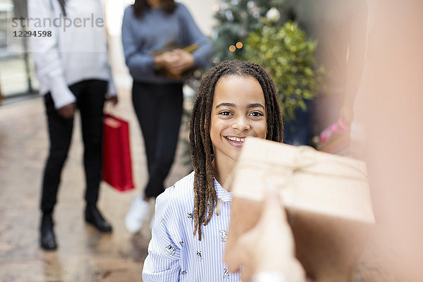 Lächelndes Mädchen erhält Weihnachtsgeschenk