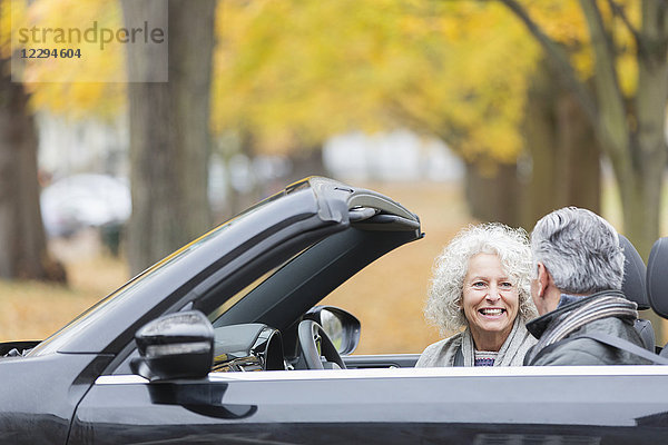 Lächelndes Seniorenpaar im Cabriolet