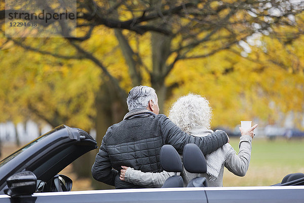 Seniorenpaar mit Cabrio im Herbstpark