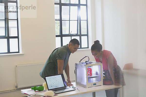 Designer beobachten 3D-Drucker im Büro