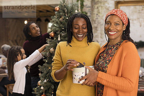 Portrait lächelnde Schwestern mit Weihnachtsgeschenk