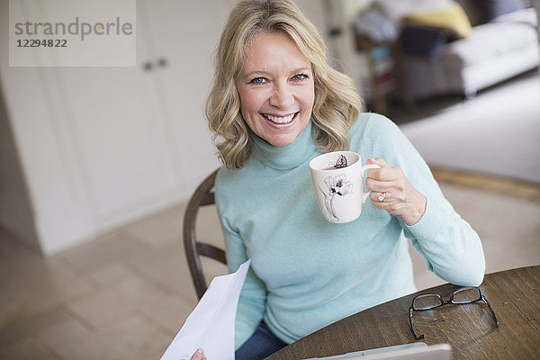 Porträt lächelnde  selbstbewusste reife Frau beim Teetrinken