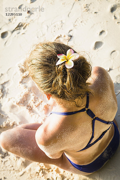 Hochwinkelansicht der mittleren erwachsenen Frau im Bikini beim Meditieren am Strand