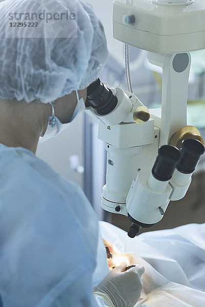 Chirurg mit Maschinen während der Augenchirurgie