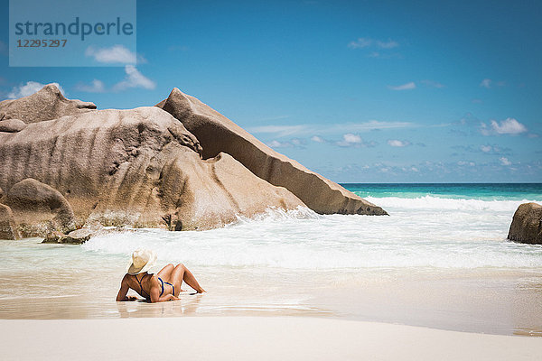 Rückansicht der mittleren erwachsenen Frau im Bikini am Strand gegen den blauen Himmel  Seychellen