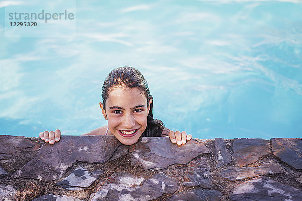 Hochwinkel-Porträt des lächelnden Mädchens am Pool