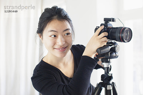 Lächelnde junge Frau beim Fotografieren mit der Kamera