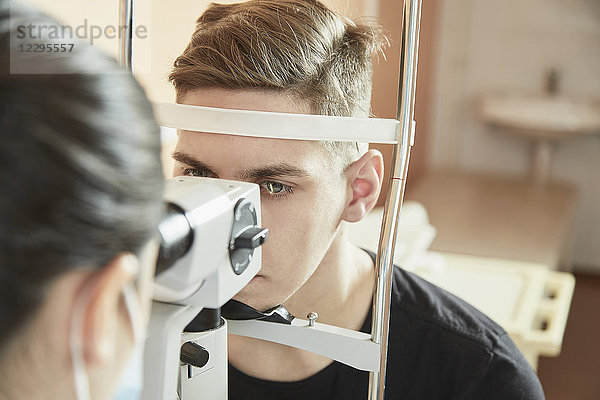 Augenarzt bei der Untersuchung des männlichen Patienten während des Sehtests im Krankenhaus