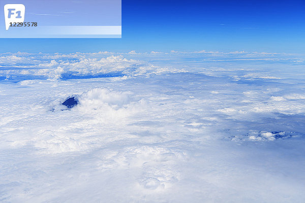 Blauer Himmel über den Wolken aus einem Flugzeug