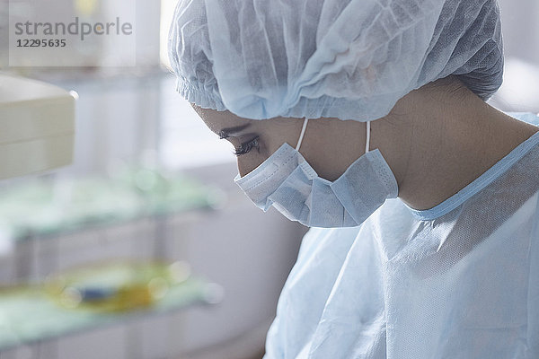 Nahaufnahme des Chirurgen mit OP-Maske und Kappe im Operationssaal