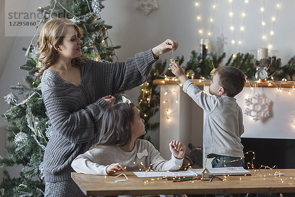 Verspielte Frau mit Kindern zu Hause zu Weihnachten