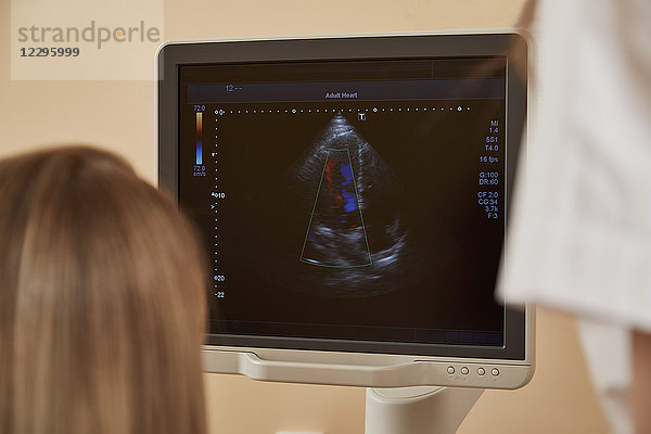 Rückansicht des Arztes und der Krankenschwester beim Betrachten des Ultraschallgerätes im Krankenhaus