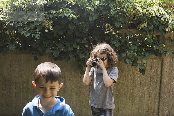 Mädchen fotografiert Freundin im Hinterhof