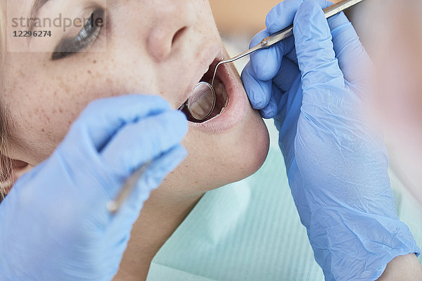 Beschnittenes Bild des Zahnarztes bei der Untersuchung des Patientenmundes im Krankenhaus
